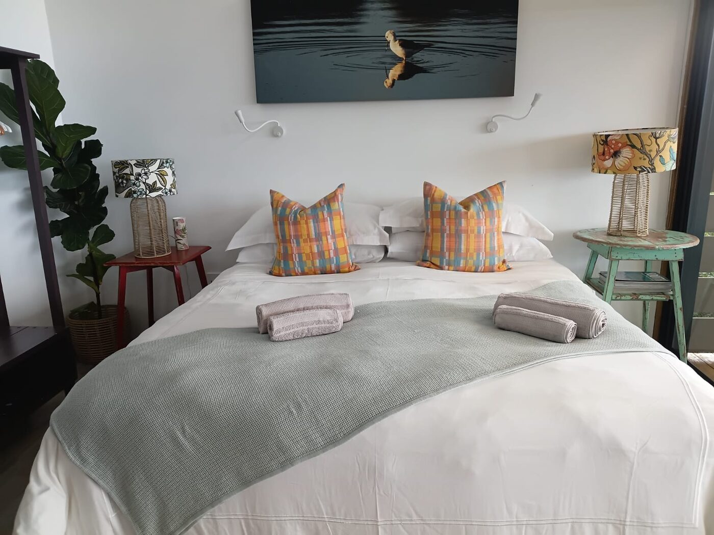 Freshly made bed with folded linen in a Garden Route guest bedroom cleaned by Cayroh