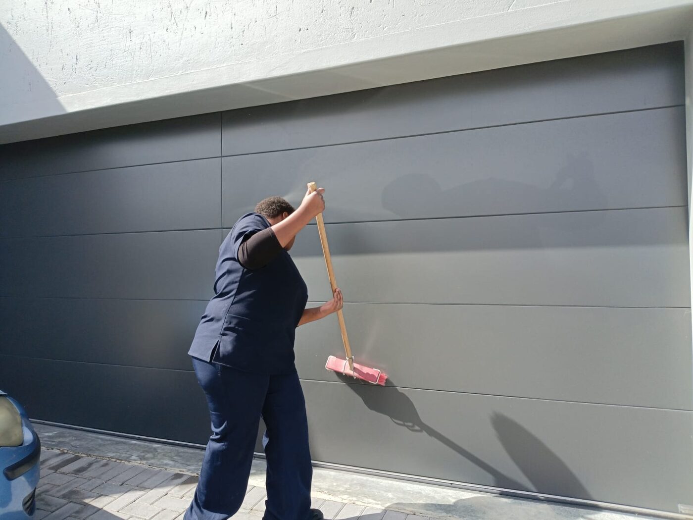 Cayroh team member washing down a garage door outside a home in George