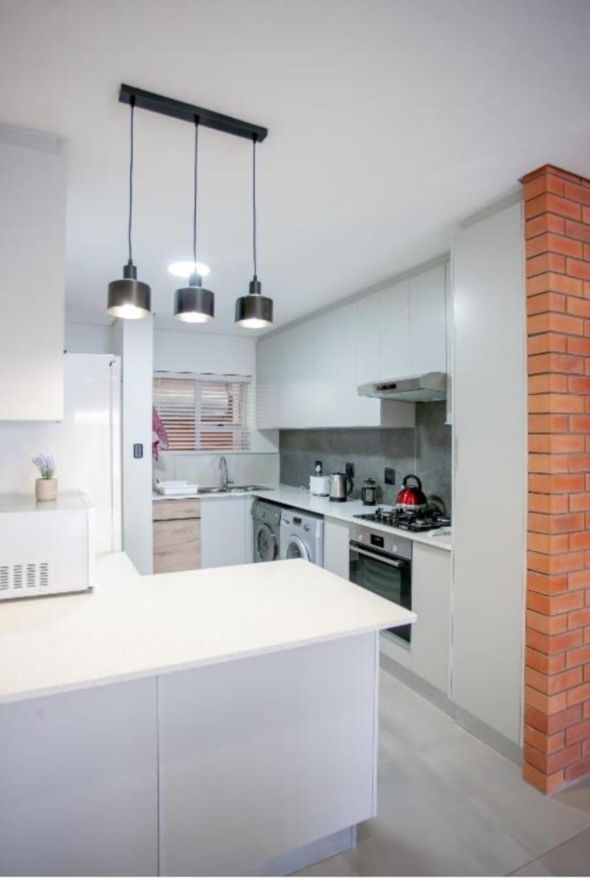 Clean white kitchen with pendant lights and clear worktops after a Cayroh clean
